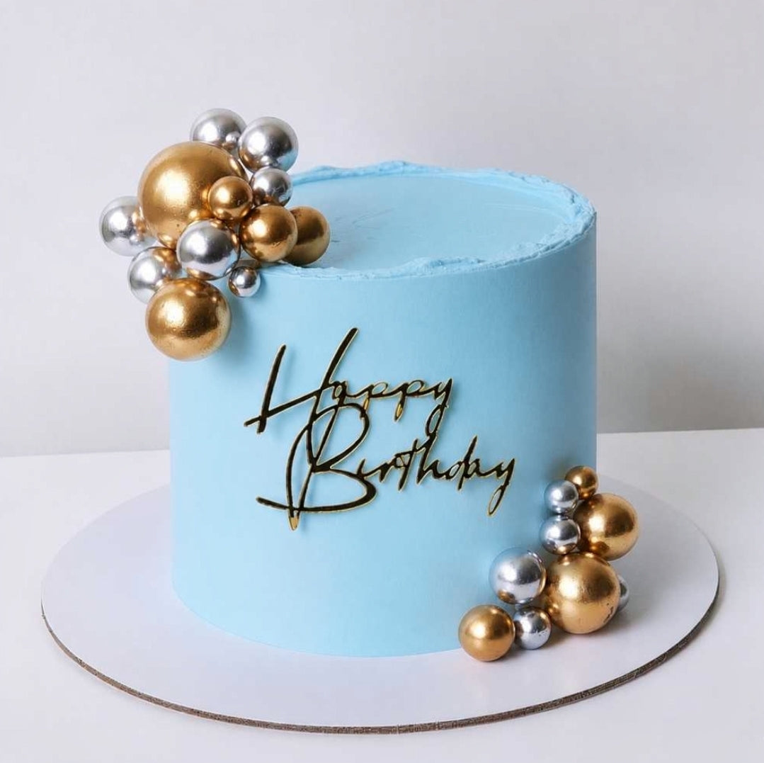 Light blue birthday cake with gold and silver spherical decorations and 'Happy Birthday' text. Sydney 
