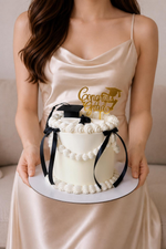 white graduation cake with black ribbons and 'Congrats Grad' topper. Sydney 