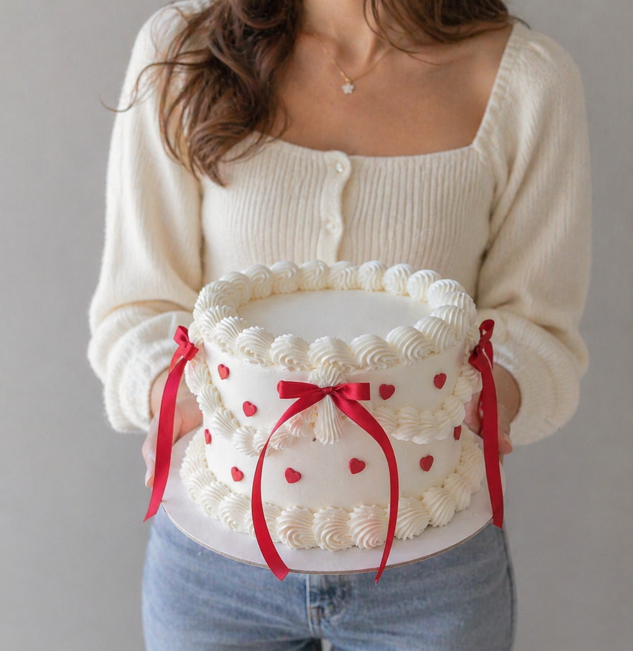 white cake with red ribbons and heart decorations sydney