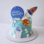 Space-themed birthday cake with astronaut, rocket, and planet decorations on a white background