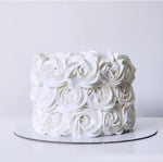 White cake with rose-shaped frosting on a white background