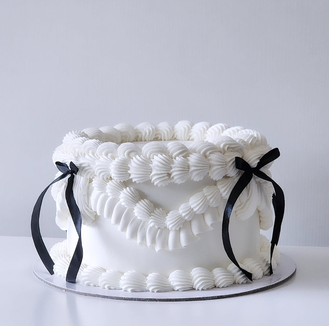 White textured cake with black ribbons 