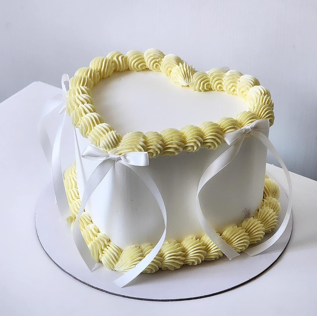 Decorative cake with yellow and white icing on a white background