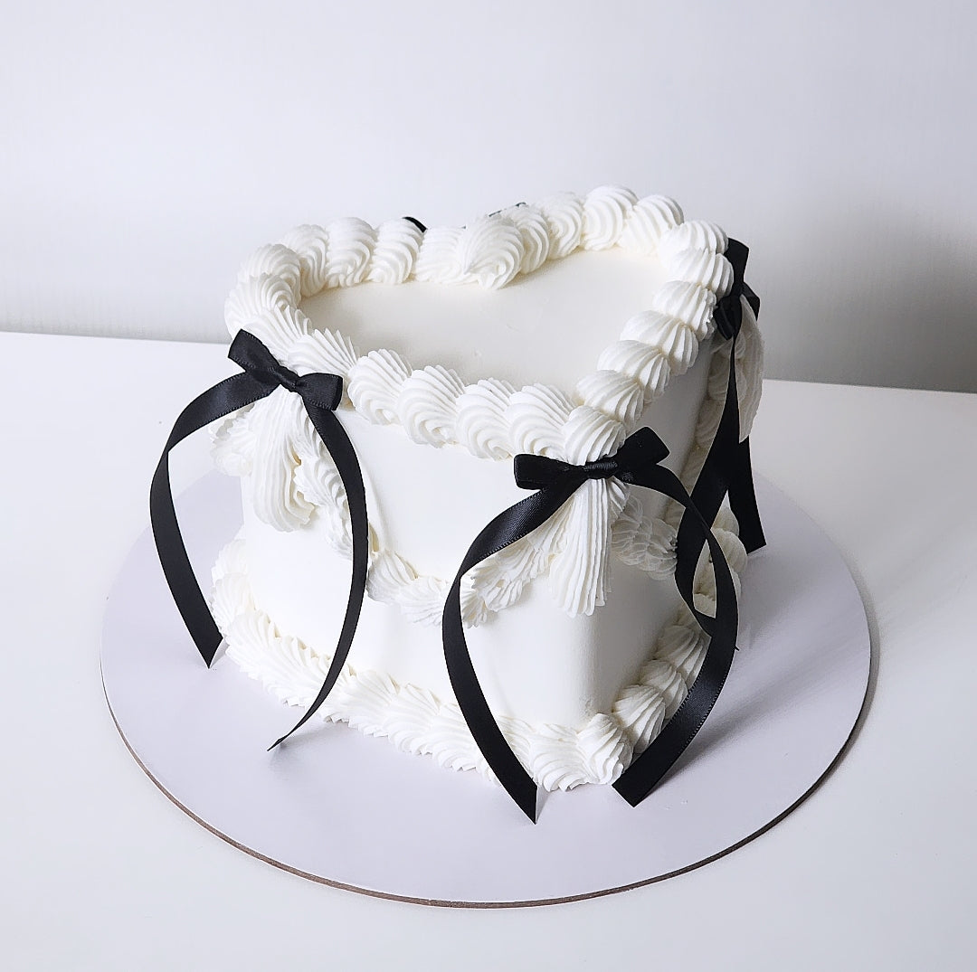 White heart cake with black ribbons sydney