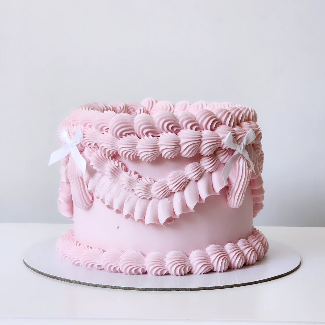 Pink cake with decorative ruffles on a white background